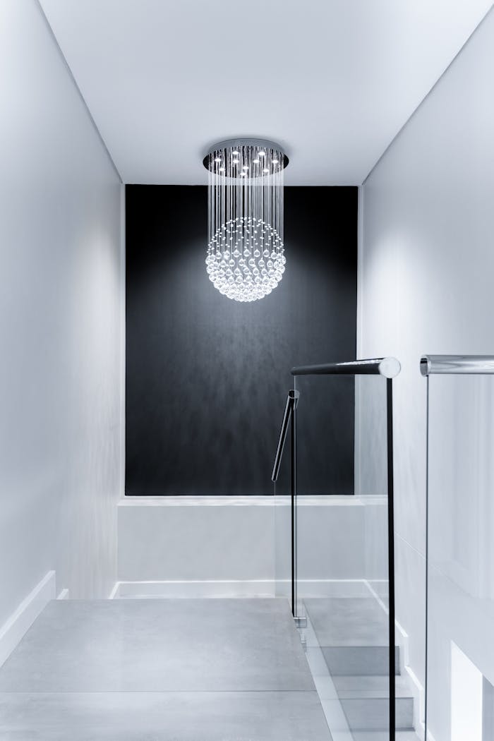 our-story-01 Sleek contemporary hallway featuring a stunning glass chandelier and minimalist design.